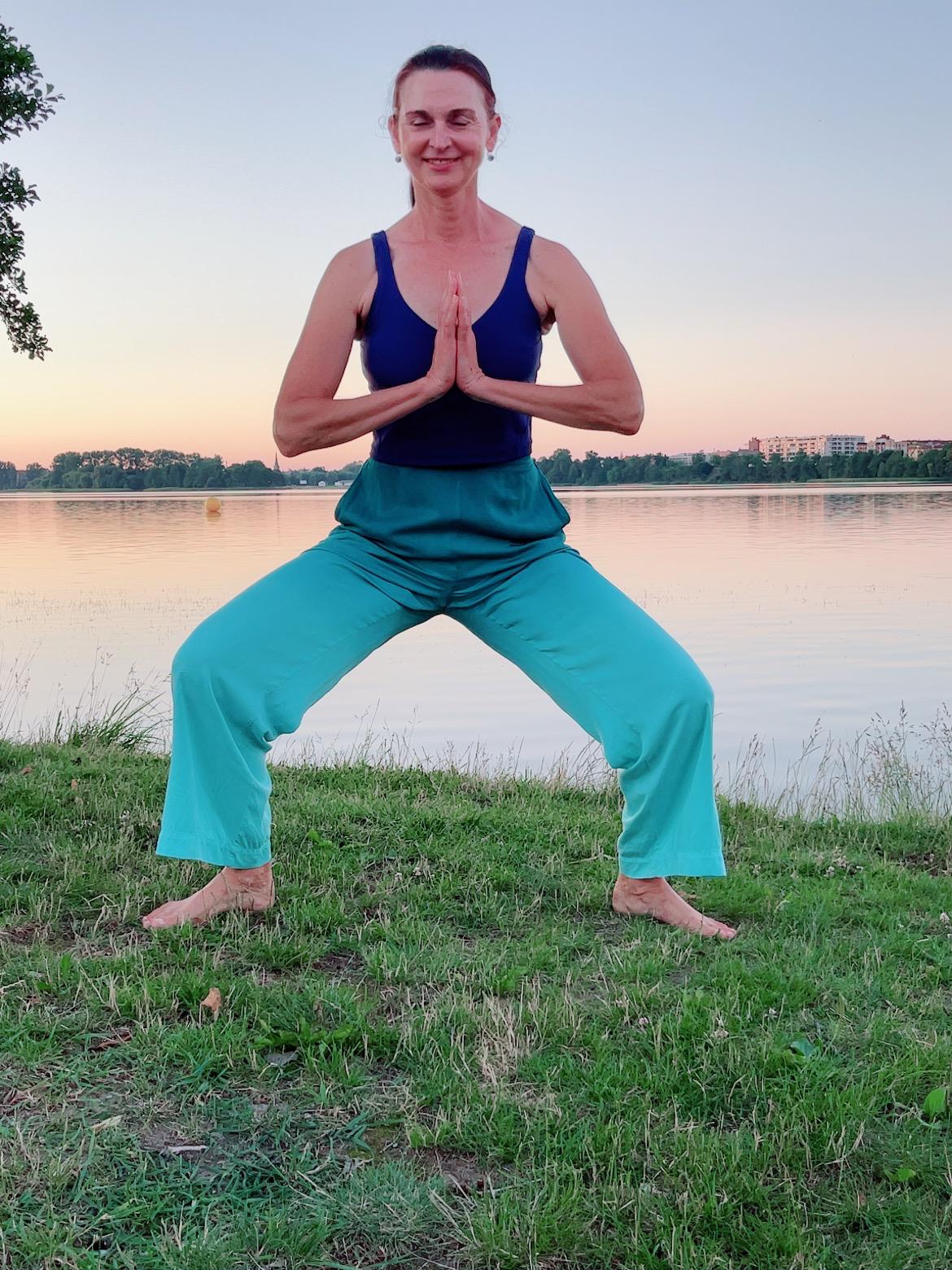 Urszula practicing mindful movement beside a lake